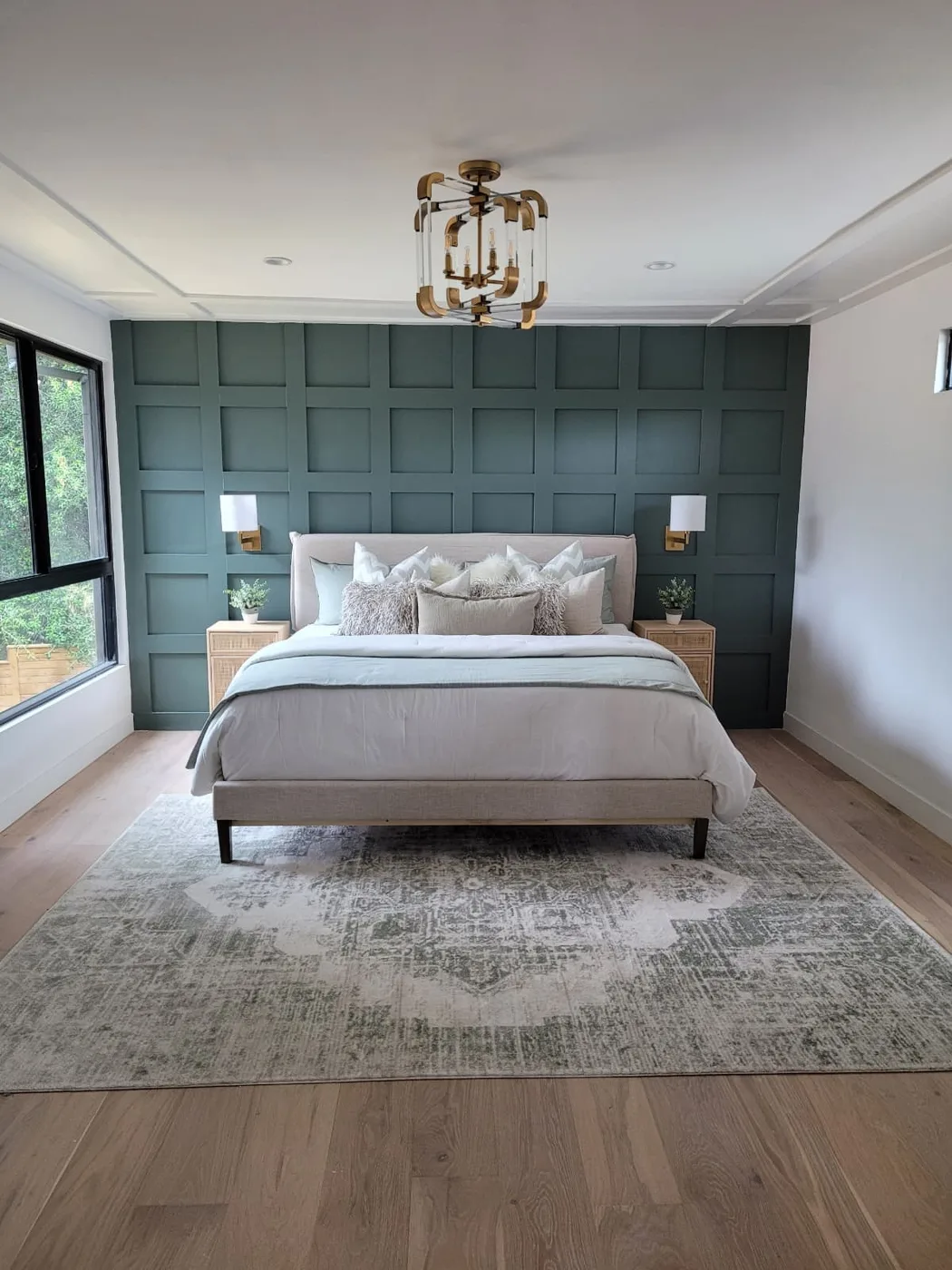 Completed bedroom remodel with custom wall paneling, trim, lighting, and flooring